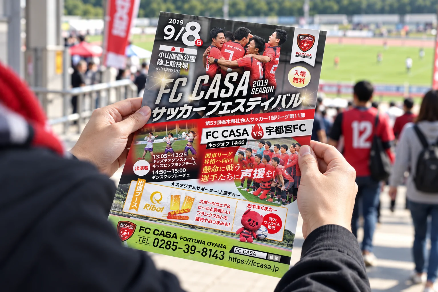 スタジアムでFC CASA様のイベントフライヤーを確認する様子