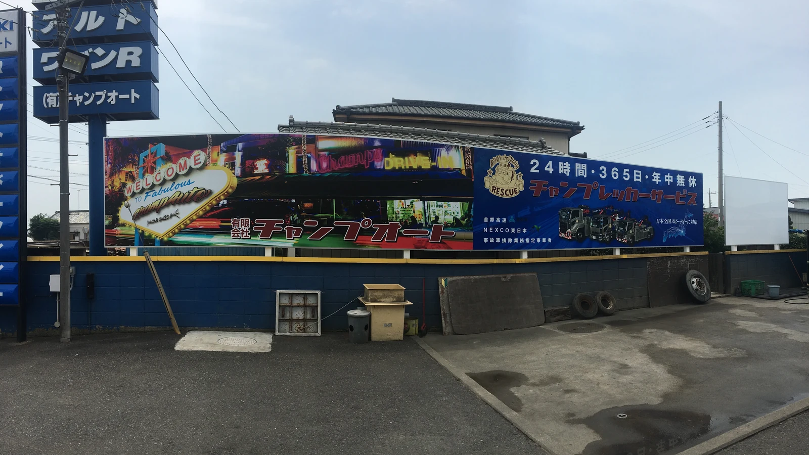 店舗外壁に設置されたチャンプオート様とレッカーサービスの看板
