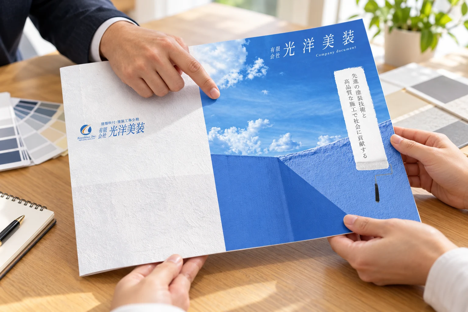 打ち合わせで光洋美装様の会社案内フォルダーを確認する様子