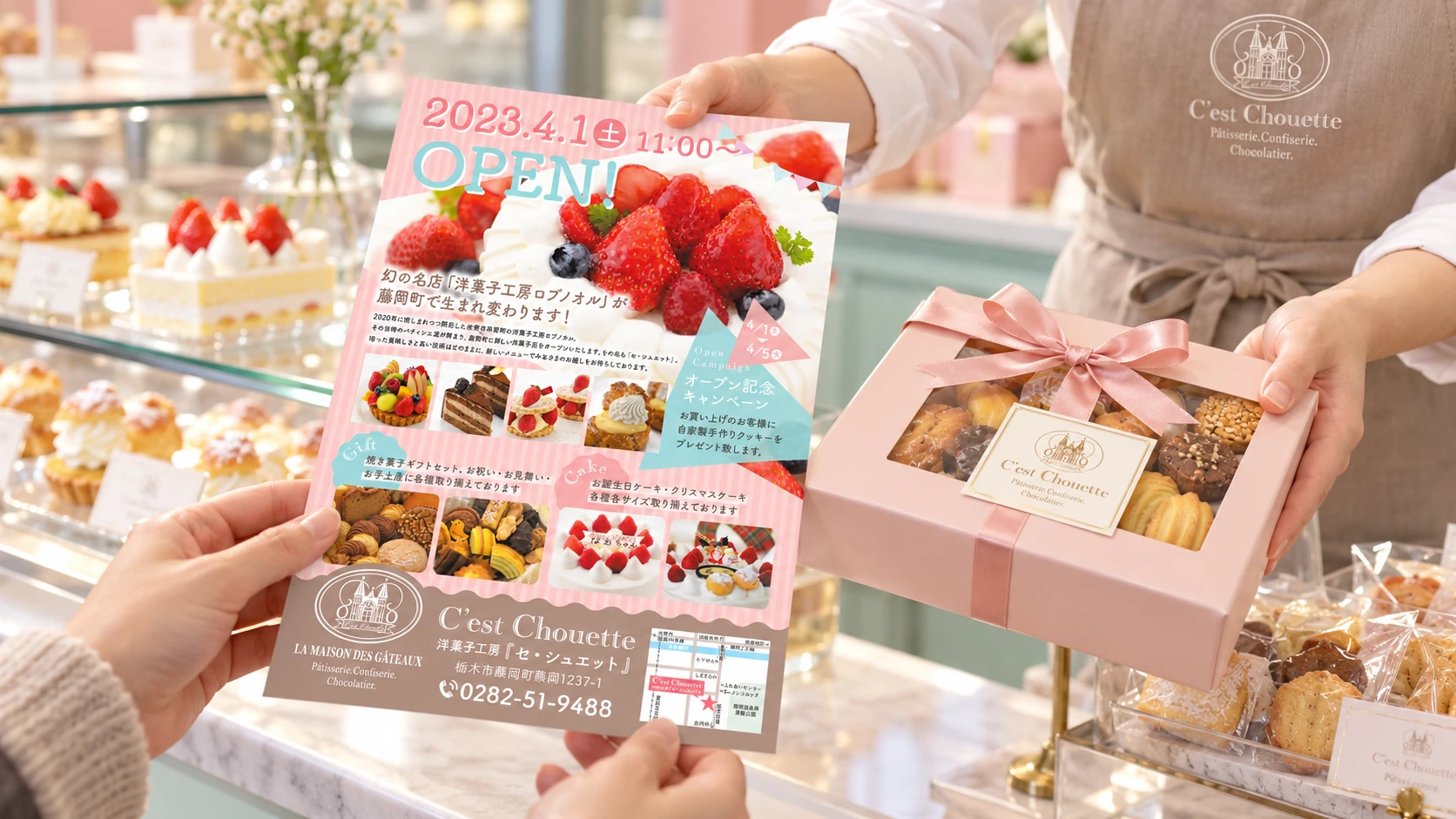 洋菓子店のカウンターで開店フライヤーと焼き菓子を受け取る様子